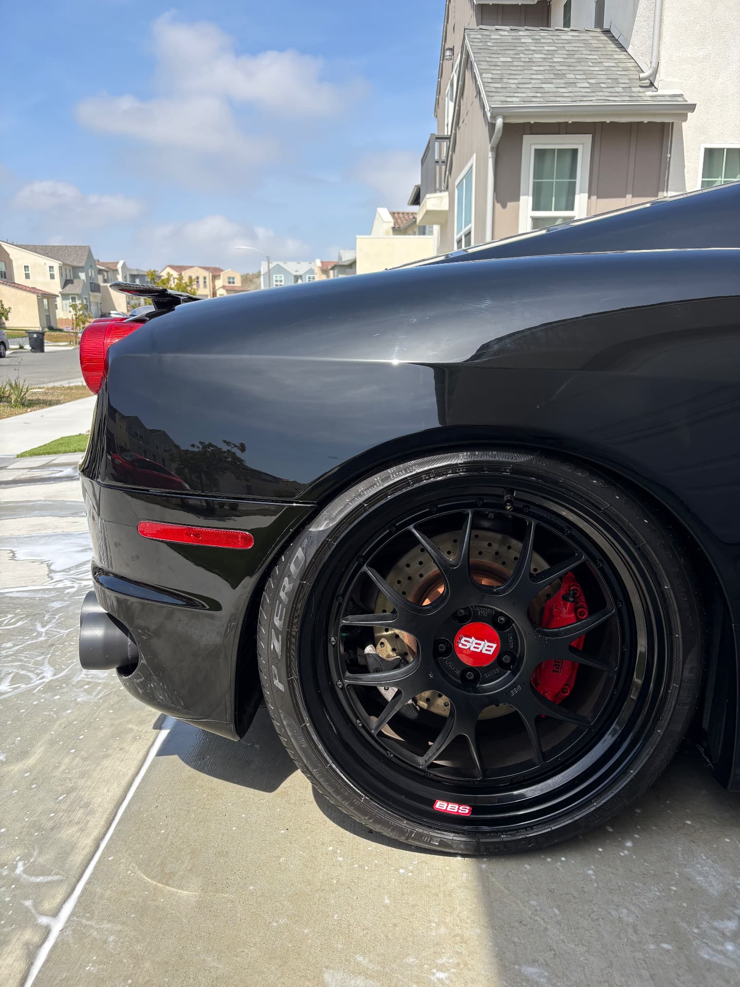 Black sports car rear quarter showing a glossy finish and detailed wheel